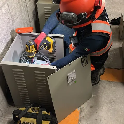 Técnico de Delta realizando mantenimiento eléctrico